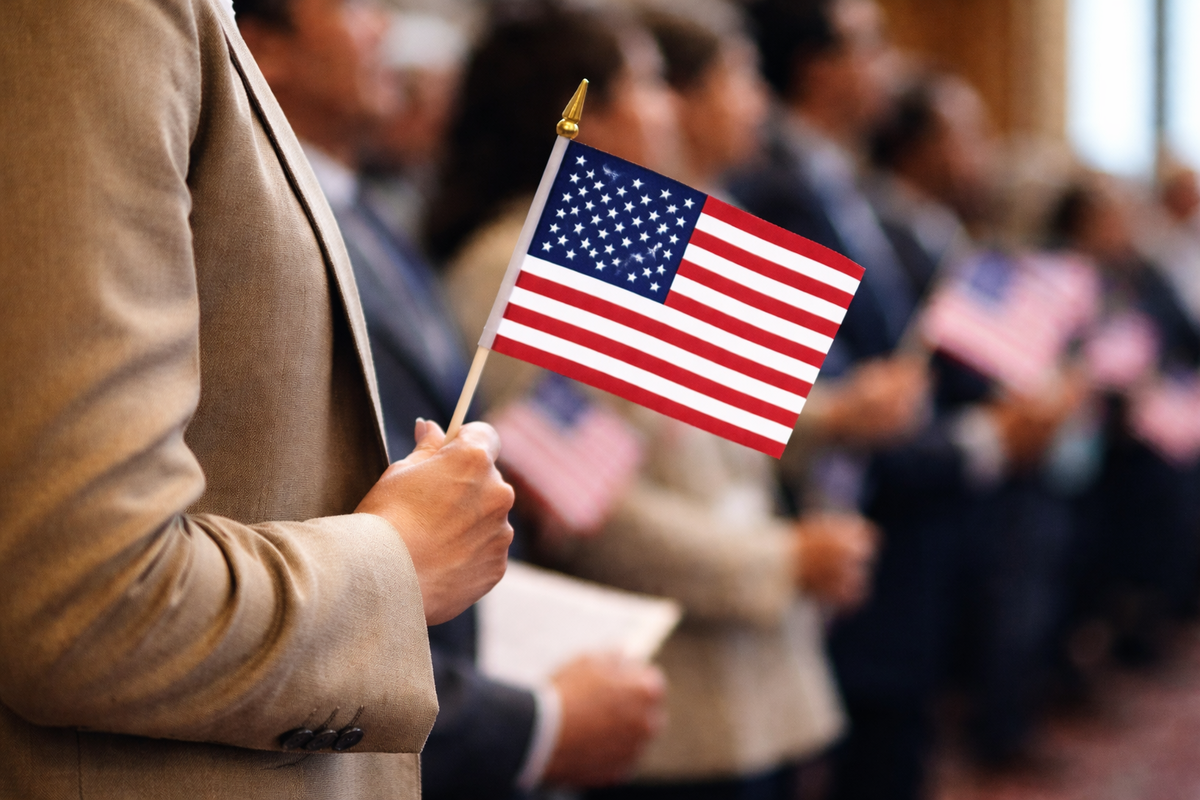 cómo obtener la ciudadanía americana en ceremonia de naturalización con bandera de Estados Unidos