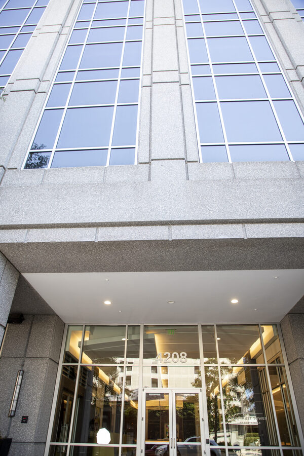 Exterior entrance of a modern office building with glass doors and tall windows for J Kelley Law Group’s local immigration law office section.