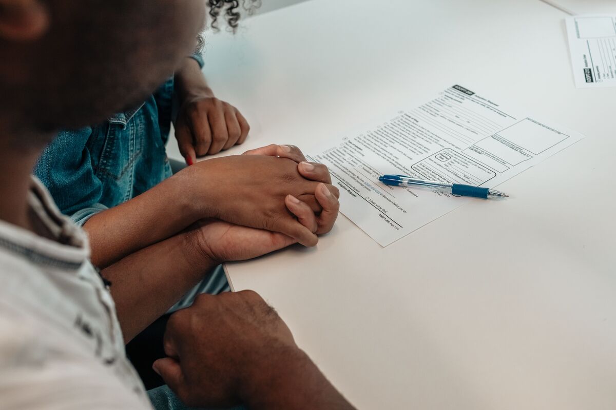 Family holding hands near immigration documents during an asylum consultation with J Kelley Law Group