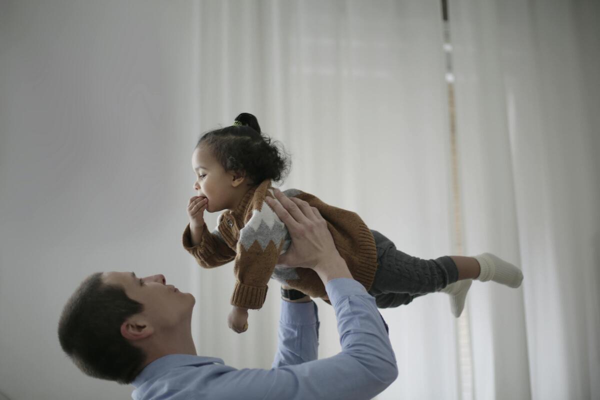 Parent lifting a young child at home, representing legal support for child support matters involving Maryland families.