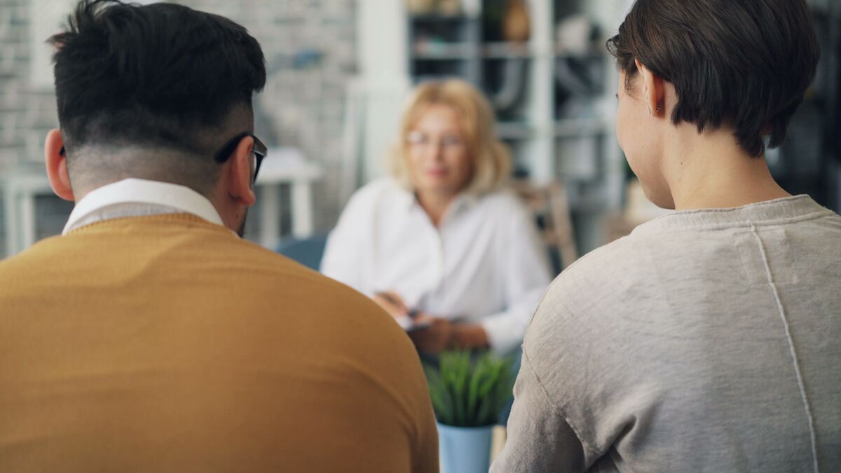 Dos personas reunidas con una profesional durante una consulta, representando la revisión inicial de un caso de derecho de familia en Maryland.