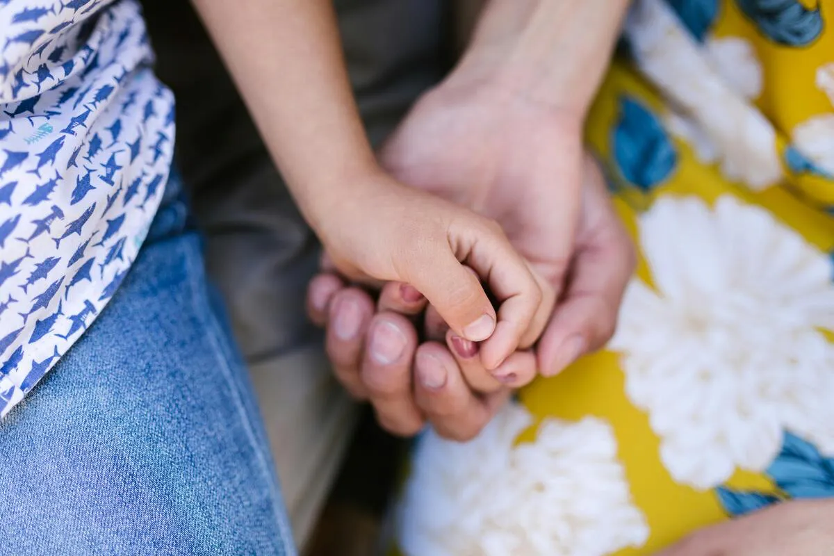 Adulto sosteniendo la mano de un menor, representando apoyo en casos de custodia SIJS en Maryland.