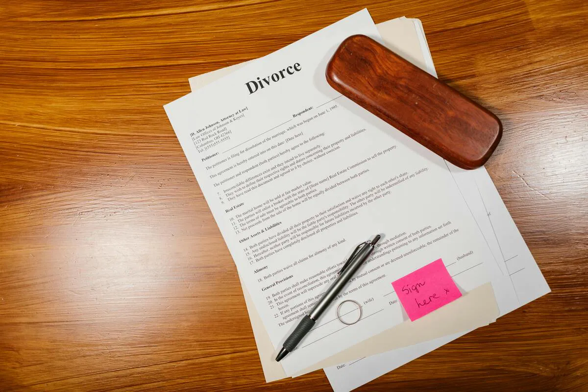 Documentos de divorcio sobre una mesa con un mazo, un anillo y un bolígrafo, representando servicios de divorcio en Maryland.
