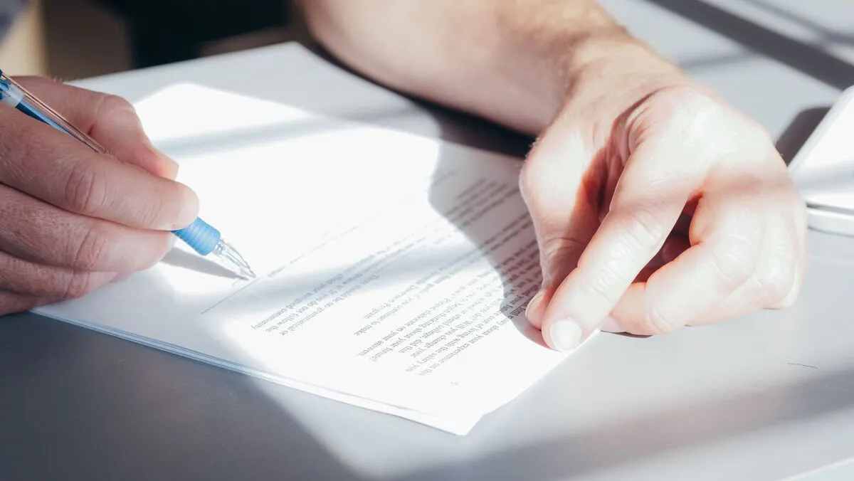 Persona escribiendo en documentos legales, representando la preparación y presentación de documentos en un caso de derecho de familia en Maryland.