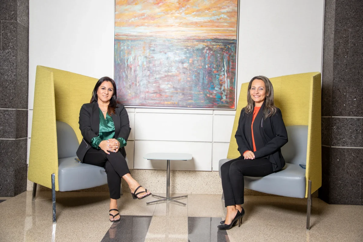Johanna Kelley and the Raleigh Office Manager seated in a professional office setting, representing legal guidance and bilingual immigration support from J Kelley Law Group.