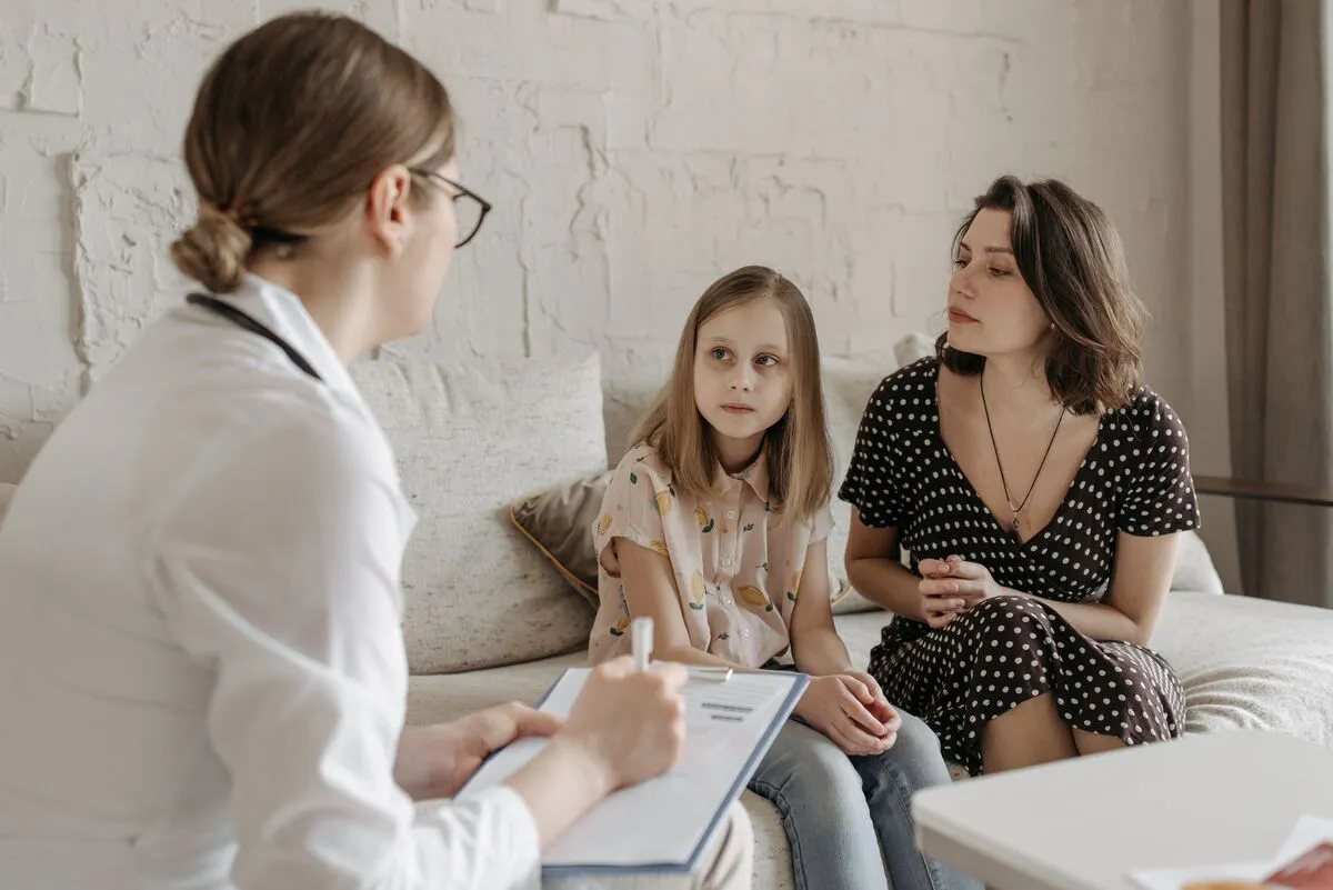 Madre e hija en una consulta revisando documentos, representando preparación para un caso de pensión alimenticia en Maryland