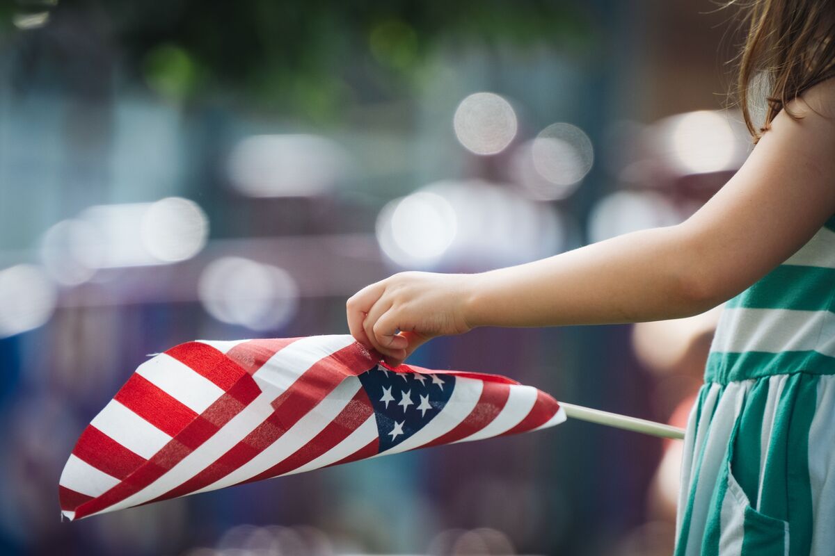 Menor sosteniendo una bandera de Estados Unidos para ayuda migratoria de Estatus Especial de Inmigrante Juvenil