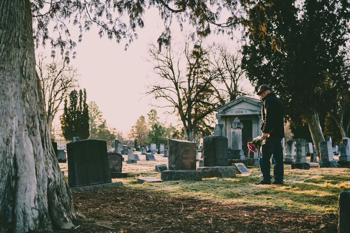 Persona visitando un cementerio mientras recuerda a un ser querido después de una muerte por negligencia en Maryland