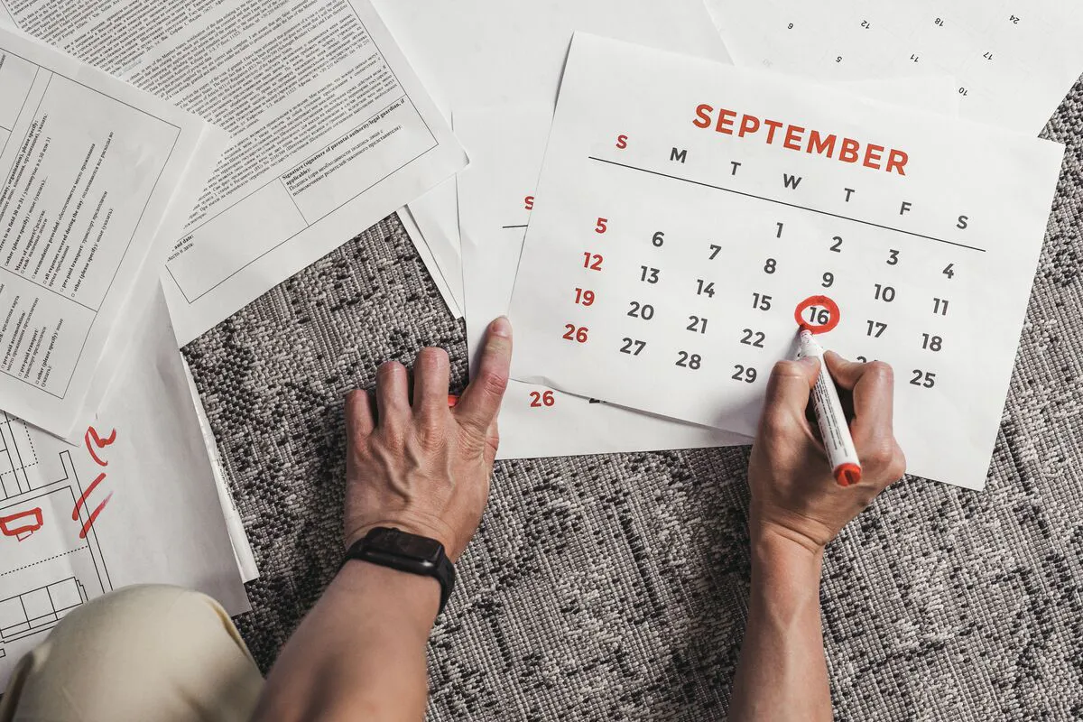 Persona revisando un calendario y documentos, representando la organización de horarios de crianza y asuntos de custodia de menores en Maryland